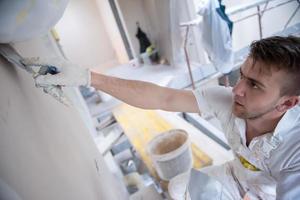 construction worker plastering on gypsum walls photo