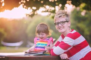 mom and her little daughter using tablet computer photo