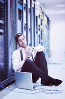 businessman with laptop in network server room photo