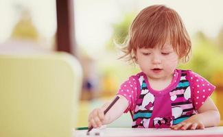 little girl drawing a colorful pictures photo