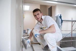 construction worker plastering on gypsum walls photo