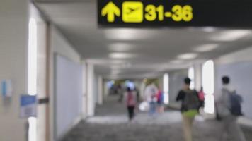 breite unscharfe Aufnahmen. menschen, die auf dem fußgängerweg spazieren gehen, sich am flugsteig am don mueang international airport terminal beeilen, reise zu reisezielen mit gepäck in der abflughalle. video