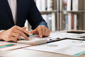 Businessmen use laptop computers and smartphones to complete online personal income tax return forms for tax payments. photo