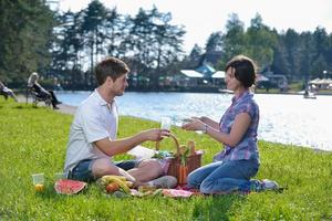 feliz pareja joven haciendo un picnic al aire libre foto