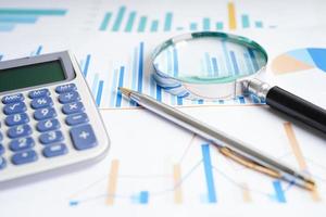 Magnifying glass on charts graphs paper. Financial development, Banking Account, Statistics, Investment Analytic research data economy. photo