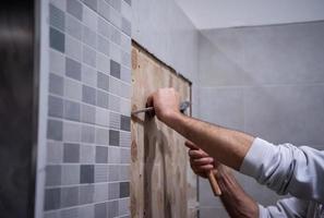 trabajador quitar demoler azulejos viejos en un baño foto