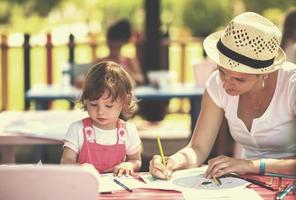 mom and little daughter drawing a colorful pictures photo