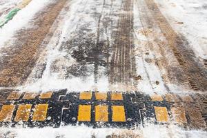 bache de velocidad en la nieve en la vía urbana en invierno foto