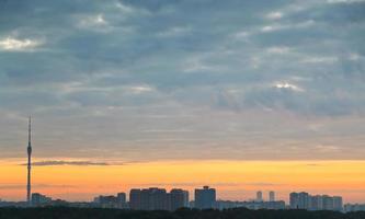 nubes grises y cielo amarillo del amanecer sobre la ciudad foto