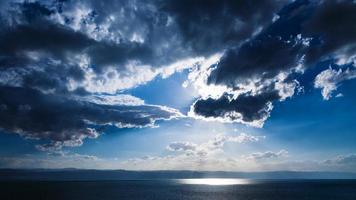 sunbeams passes through dark clouds over Dead Sea photo