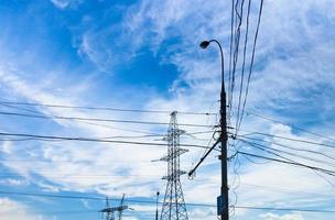 Electric power transmission under white cirrus clouds photo