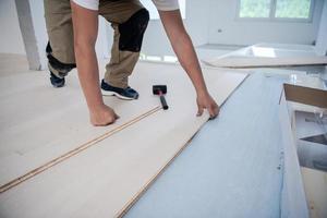 Worker Installing New Laminated Wooden Floor photo