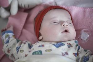 bebé recién nacido durmiendo en casa en la cama foto