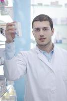 pharmacist chemist man in pharmacy drugstore photo