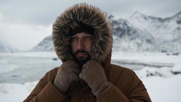 man at winter in stormy weather wearing warm  fur jacket photo