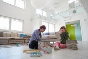 madre e hija pequeña jugando con joyas en casa foto