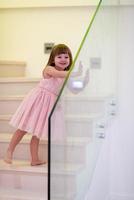 little girl playing on stairs at home photo