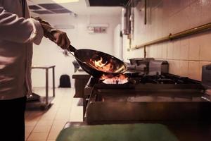 chef haciendo flambeado en la comida foto