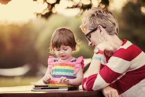 mom and her little daughter using tablet computer photo