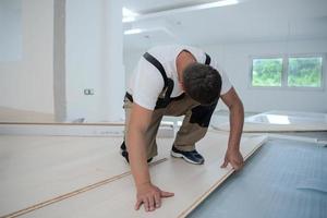 Worker Installing New Laminated Wooden Floor photo