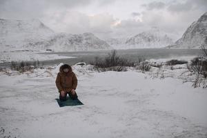 Muslim traveler praying in cold snowy winter day photo