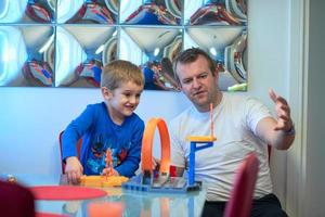 Father and children playing car toy game photo