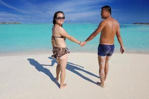 feliz pareja joven disfrutando del verano en la playa foto