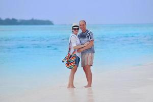 feliz pareja joven divertirse en la playa foto