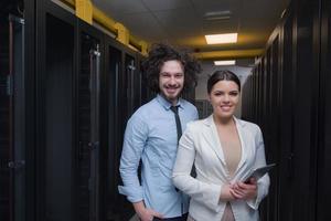 engineer showing working data center server room to female chief photo