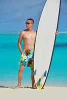 Man with surf board on beach photo