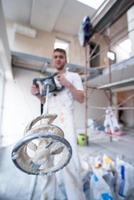 construction worker mixing plaster in bucket photo