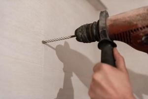 trabajador de la construcción perforando agujeros en el baño foto