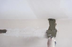 construction worker plastering on gypsum walls photo