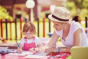 mom and little daughter drawing a colorful pictures photo