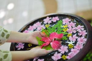 mano femenina y flor en agua foto