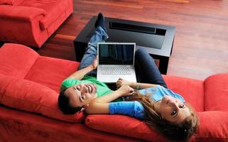 una pareja feliz se divierte y trabaja en una laptop en casa foto