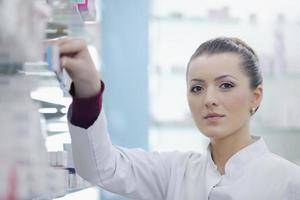 pharmacist chemist woman standing in pharmacy drugstore photo