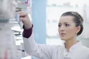 pharmacist chemist woman standing in pharmacy drugstore photo