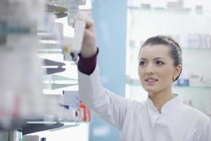 Farmacéutico químico mujer de pie en farmacia droguería foto