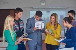 grupo de estudiantes que trabajan con el maestro en el modelo de la casa foto