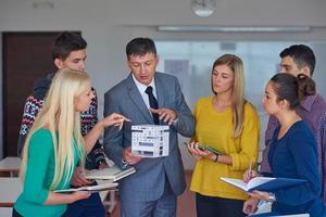 group of students working with teacher on  house model photo