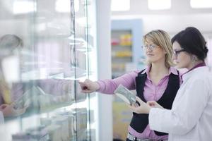 Farmacéutico sugiriendo drogas médicas al comprador en farmacia droguería foto