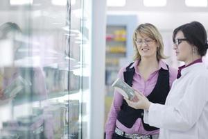 Farmacéutico sugiriendo drogas médicas al comprador en farmacia droguería foto