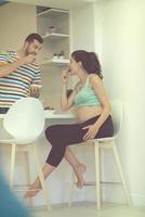 couple eating fruit strawberries at kitchen photo