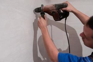 trabajador de la construcción perforando agujeros en el baño foto