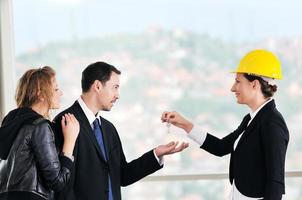 happy young couple buying new home with real estate agent photo