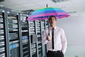 empresario sostenga paraguas en la sala de servidores foto