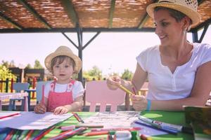 mom and little daughter drawing a colorful pictures photo