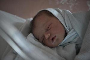 newborn baby sleeping in  bed at hospital photo
