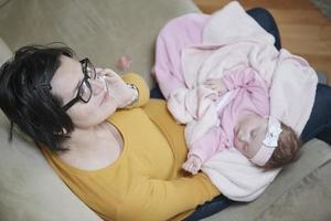 la madre está jugando con el bebé en casa foto